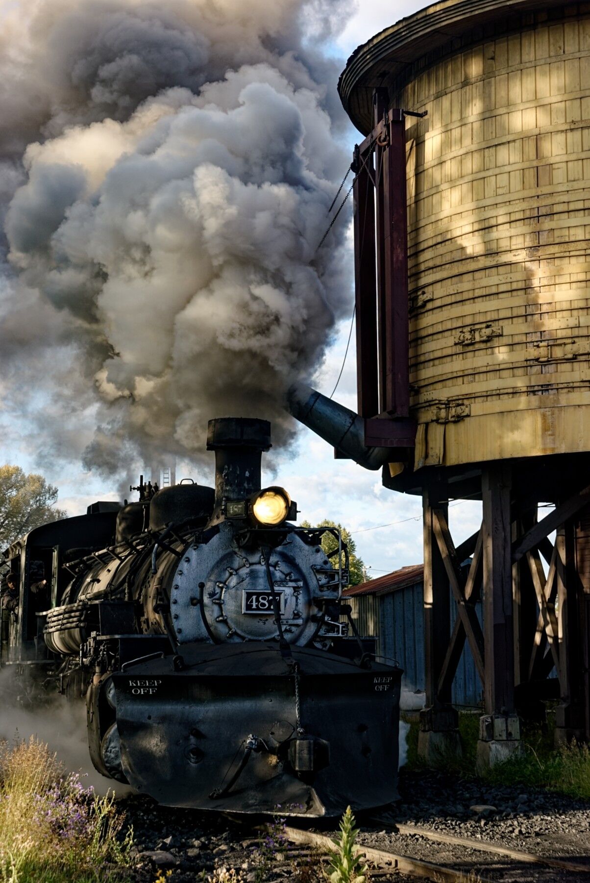 K-36 487 pulls up to the double spout water tank in Chama New Mexico. The locomotive will get a huge drink of water then resume...