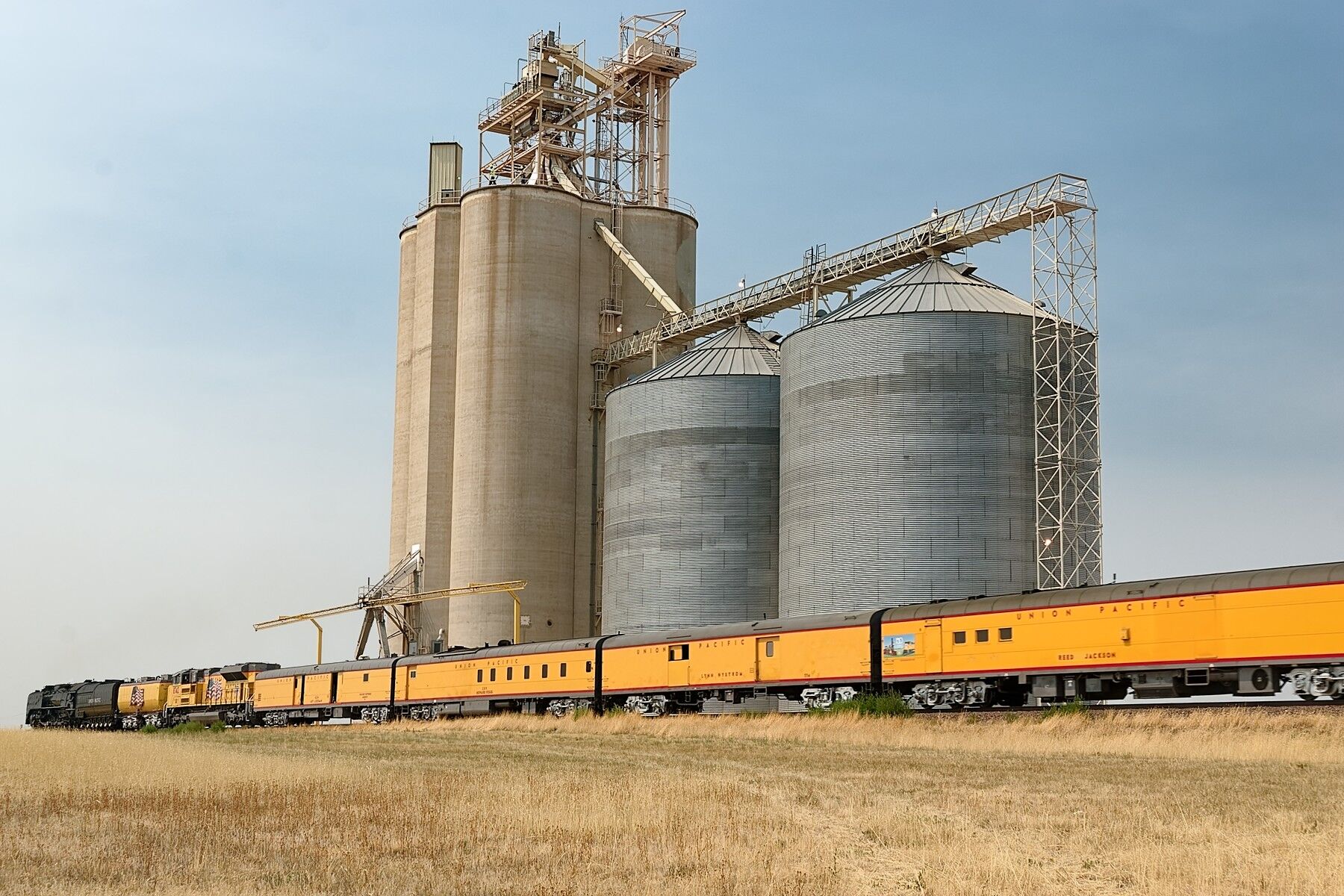 Union Pacific steam locomotive 844 goes by the big grain elevator at Byers Colorado.